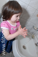 Девочка моет руки перед едой, дети учатся самостоятельности