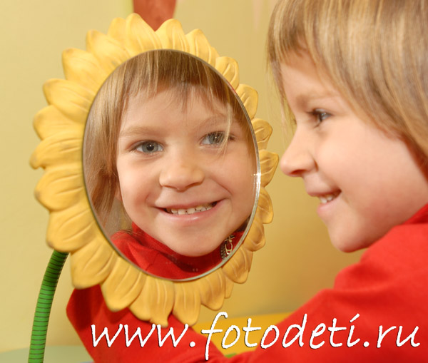 Фотографии детей. Девочка смотрит в отражение в зеркале и улыбается.