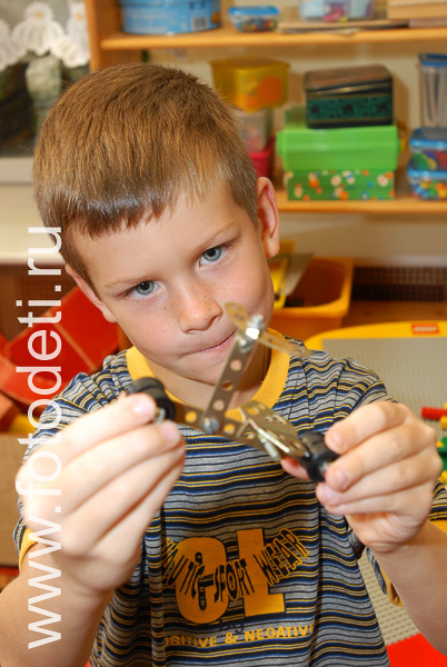 Фотографии детей в галере сайта фотодети.ру. Мальчик играет с металлическим конструктором.