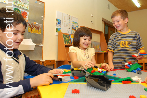 Фото детей в игре: Дети собирают лего конструктор.