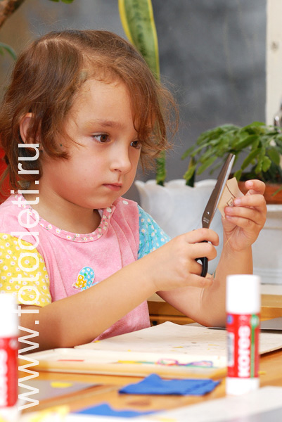 Развитие творческого потенциала ребёнка. Ребёнок пользуется ножницами на  творческом занятии в детском саду.