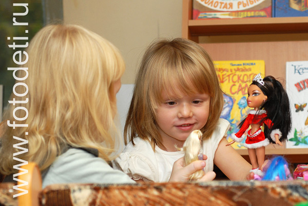 Фотография играющих детей: Девочки играют с куклами.