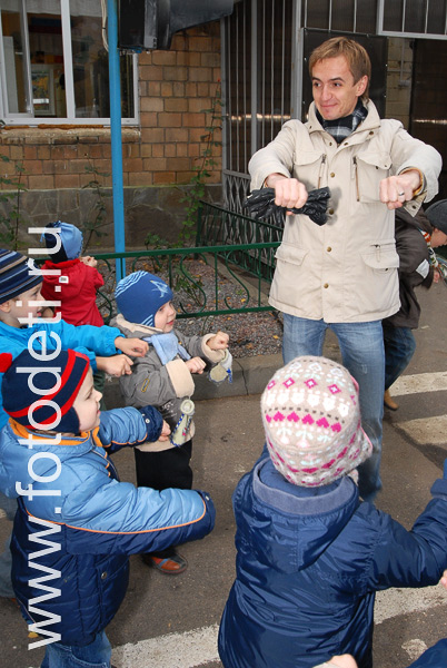 Фотографии детей в галере сайта fotodeti.ru / Мужчина играет с детьми в ролевые игры на детской площадке.