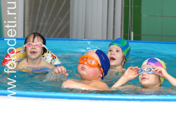 Детская физкультура. Дети в бассейне на уроке плавания в детском саду.