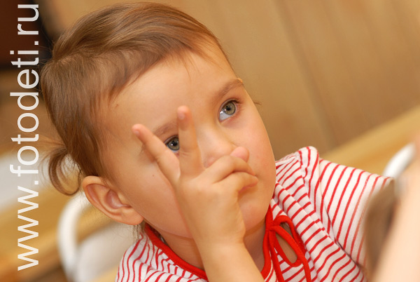 Дети на фото детского фотографа: Девочка показывает на пальцах цифру два.