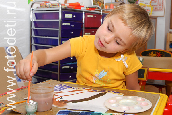 Позитивные фотографии с детьми: Ребёнок увлечённо рисует красками.