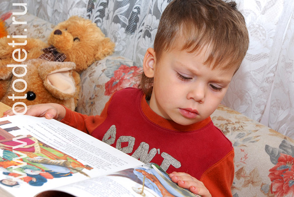 Фотографии детской игры: Ребёнок рассматривает книжку с картинками.