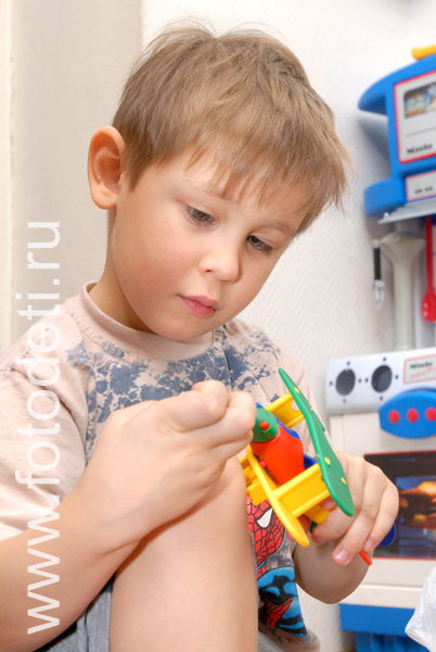 Фото детей в игре: Ребёнок собирает конструктор.