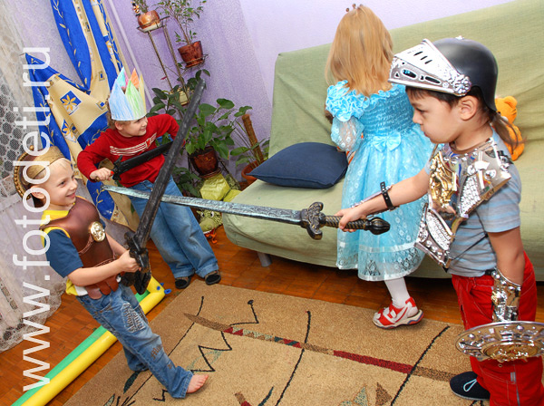 Фотографии детских праздников. Дети разыгрывают  рыцарское сражение во время праздника.