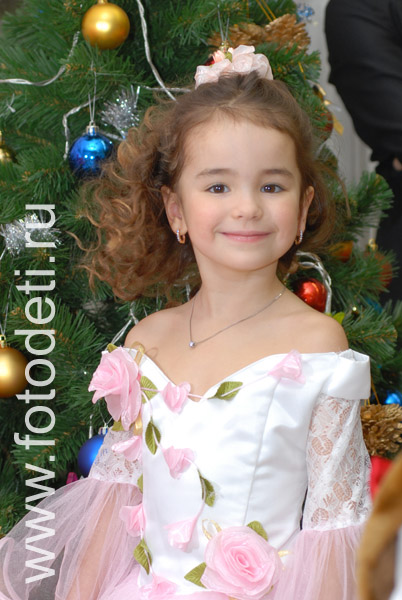 Фотографии детских праздников. Фотография счастливой девочки на фоне новогодней ёлочки.