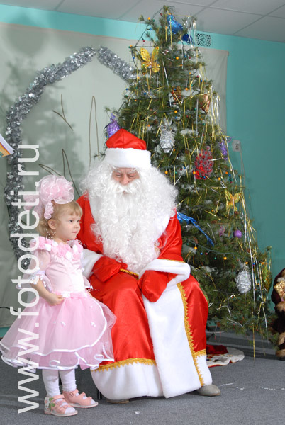 Детские утренники. Фотография маленькой девочки с Дедом Морозом.