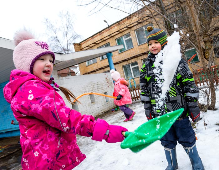 Игры со снегом на веселой фотосессии в детском саду во время прогулки