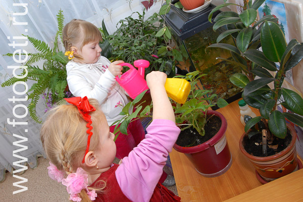 Развитие детей. Дети поливают цветы в детском саду.
