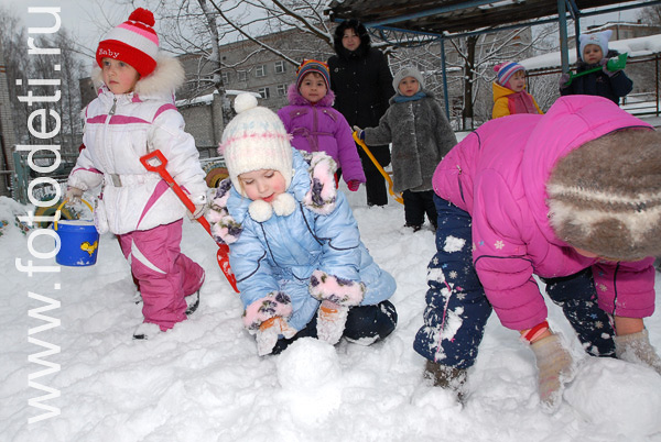 Фото детей в игре: Дети катают колобки из снега.