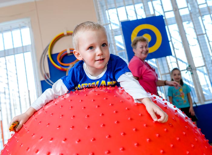 Веселый мальчик на огромном красном шаре
