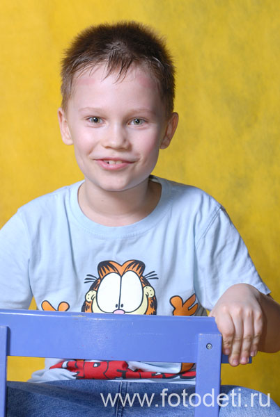 Фотографии детей из архива детского фотографа. Портрет весёлого светленького мальчика на желтом фоне.