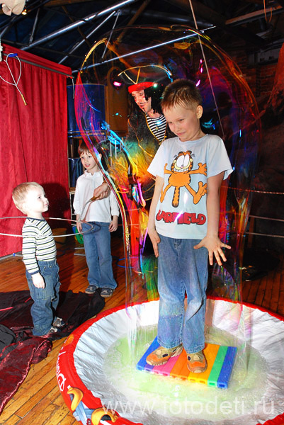 Автор фотографии: детский фотограф Игорь Губарев. Ребёнок внутри огромного мыльного пузыря на шоу мыльных пузырей.