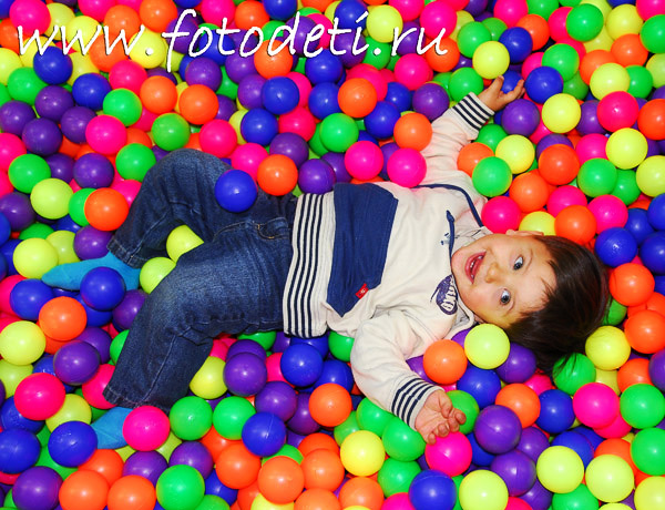 Фото из архива детского фотографа Игоря Губарева. Счастливый малыш в бассейне с разноцветными шариками.
