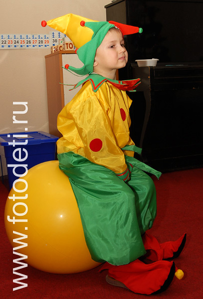 Фотогалерея детских праздников в разделе «Фото детей». Мальчик в костюме петрушки прыгает на шаре.