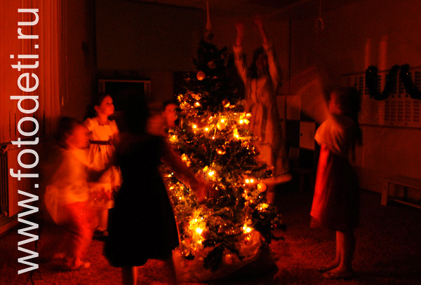 Фото детей на праздниках. Дети водят хоровод вокруг, светящейся в темноте ёлочки.