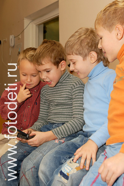 Фото детей в игре: Дети играют с электронной игрушкой.