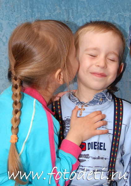 Фотографии детей. Сестрёнка целует брата в щёчку.