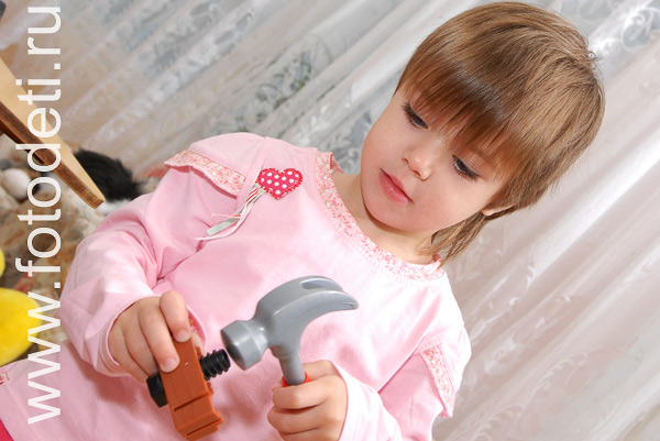 Фотография играющих детей: Девочка учиться мастерить с молотком.
