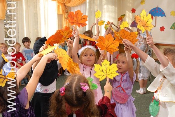 Фотографии детей из архива детского фотографа. Дети танцуют танец с листьями на детском празднике.