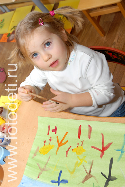 Детские творческие студии. Девочка с голубыми глазами рисует.