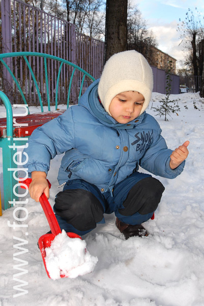Фото детей в игре: Мальчик копает снег.
