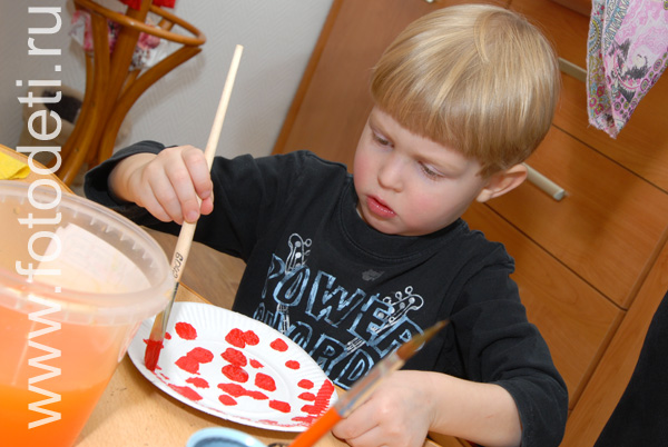 Творческое развитие детей. Мальчик расписывает тарелочку.