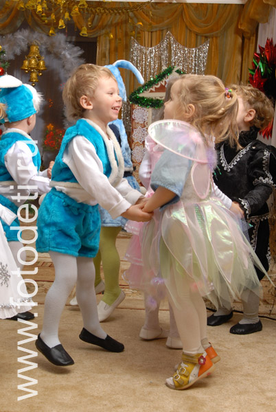 Фотографии детей на праздниках. Дети танцуют под ёлочкой на новогоднем утреннике.