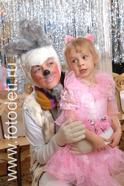 Дети на празднике. Девочка сидит на руках у сказочного зайца на утреннике.