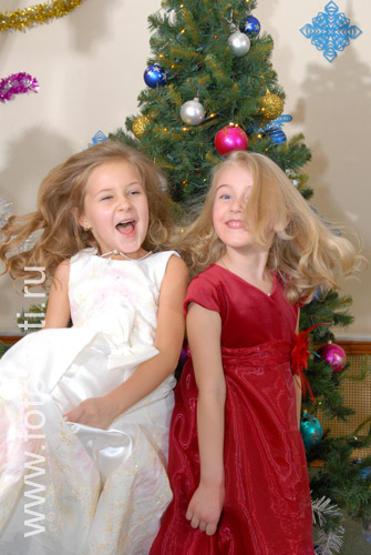 Общение детей. Две подружки на новогоднем празднике, динамичный снимок.