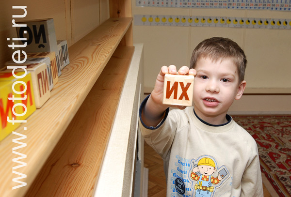 Фотографии детской игры: Фотография мальчика с кубиком.
