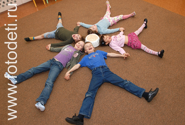 Творческое развитие детей. Группа детей лежит на полу в виде большой снежинки.