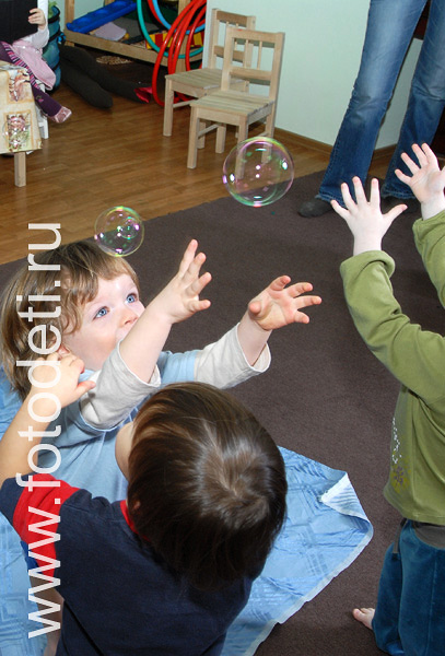 Фото детей в игре: Малыш играет с мыльными пузырями.