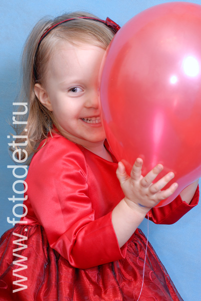 Фотографии детей в авторском фотобанке. Девочка прячется за шариком.