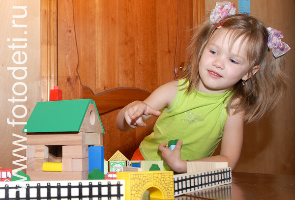 Фотографии детей. Девочка строит дом.