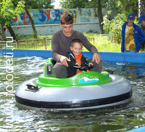 Фото детей в игре: Папа с сыном катаются на лодочке с мотором.