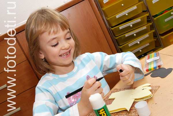 Детские творческие студии. Девочка мастерит фигурку из бумаги.