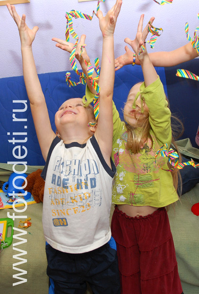 Фотографии детей на праздниках. Дети ловят летящий серпантин на празднике.