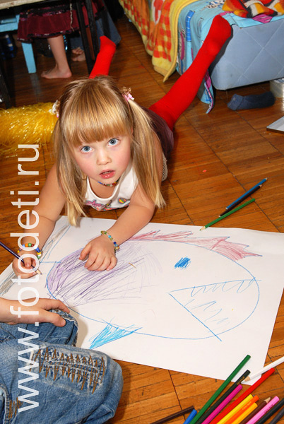 Эстетическое развитие детей. Девочка рисует рыбу на ватмане.