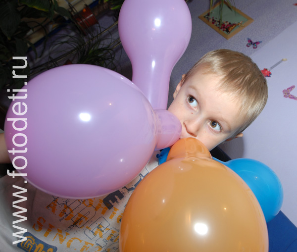 Детские утренники. Мальчик с воздушными шарами на детском празднике.