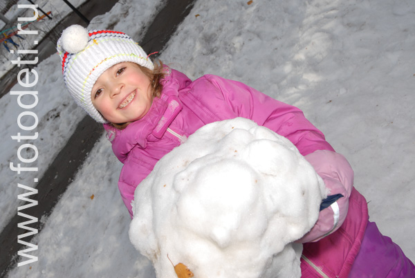 Фото детей в игре: Девочка лепит снеговика.