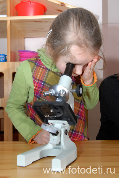 Фотографии детей на авторском сайте детского фотографа. Девочка смотрит в микроскоп на исследовательском занятии в детском саду.