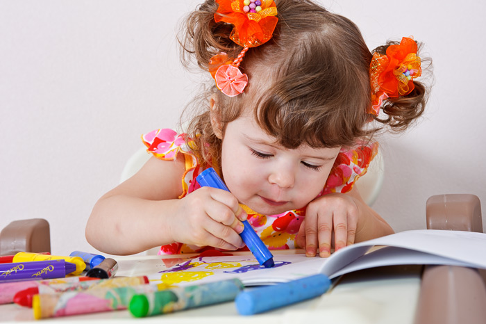 Фото Игоря Губарева: Маленькая девочка с мелками для рисования увлеченно творит.