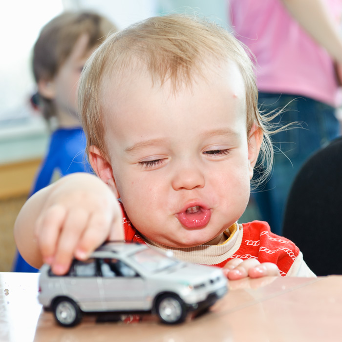 Профессиональное фото ребёнка / Мальчик с машинкой играет на отдыхе семейного клуба.
