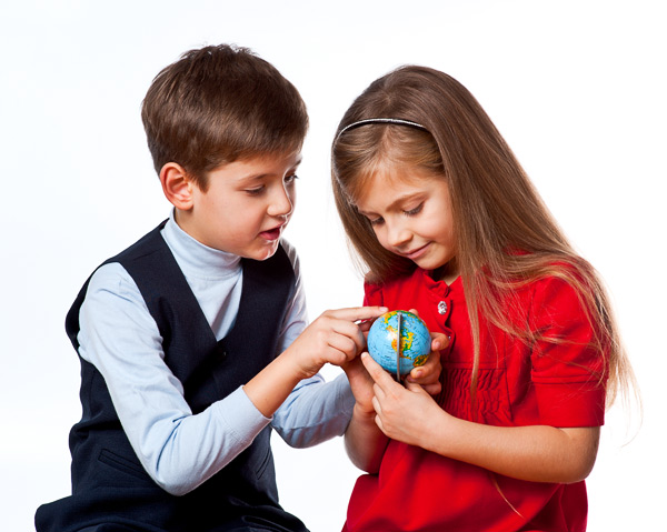 Мальчик и девочка (дошкольники) держат в руках глобус, с интересом его рассматривая. Фотография, ID 17196