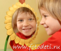 Девочка смотрит в отражение в зеркале и улыбается, забавные фотографии детей на сайте детского фотографа